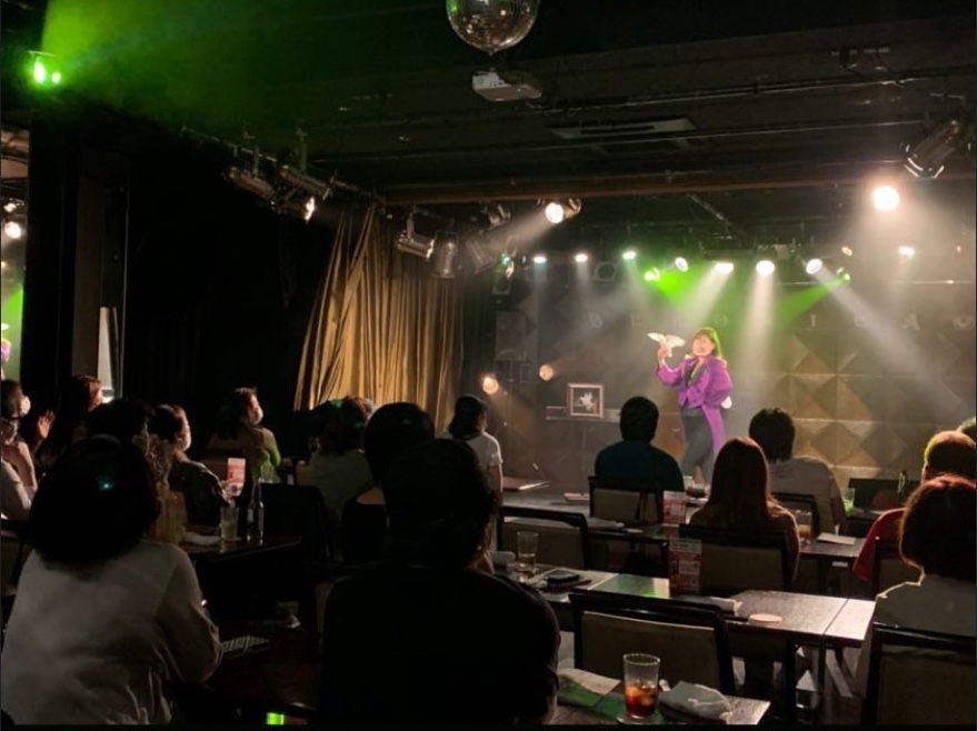 ライブハウスのステージでマジックを披露する女性マジシャンMOE